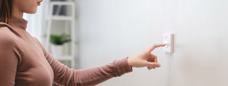 a person turning on a wall switch