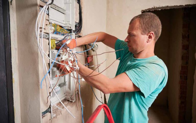 E I technician installing a new electrical panel