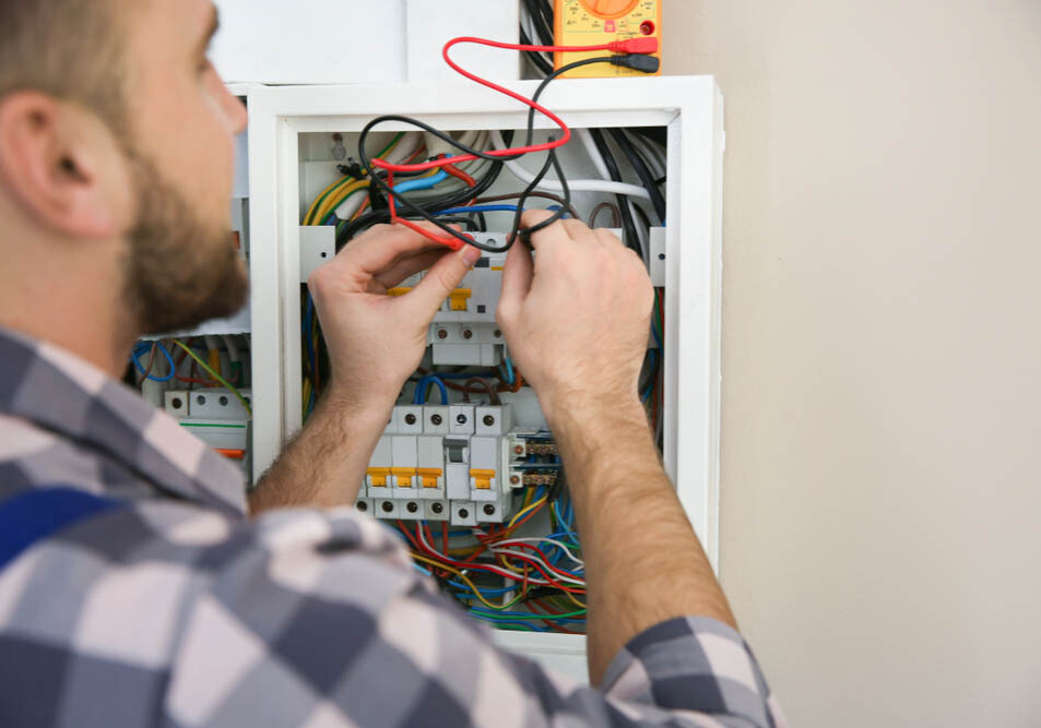 Technician tinkering with an electrical panel